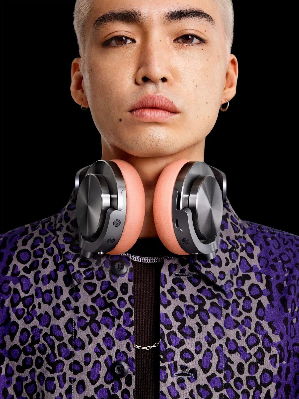 Person wearing a pair of headphones with a black background