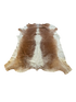 Brown and white cowhide rug on a white background