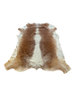 Brown and white cowhide rug on a white background