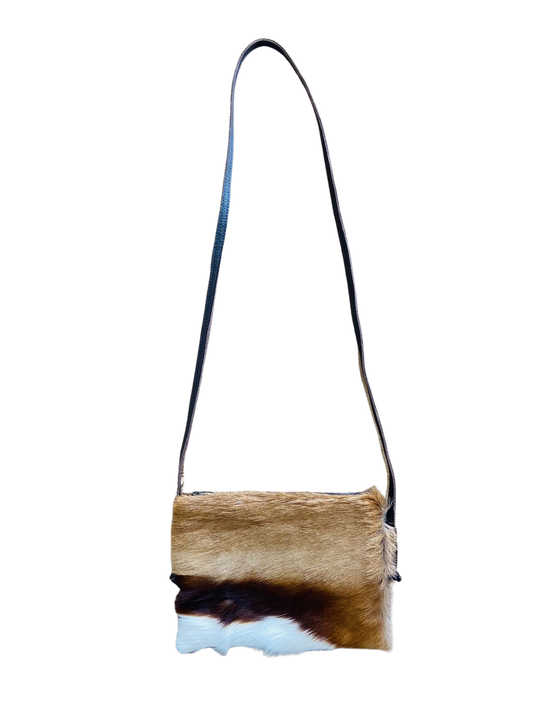 Crossbody bag with a natural cowhide pattern on a white background