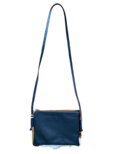 Blue leather crossbody bag with a strap on a white background