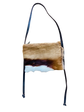 Brown and white Springbok hide bag with black strap on a white background